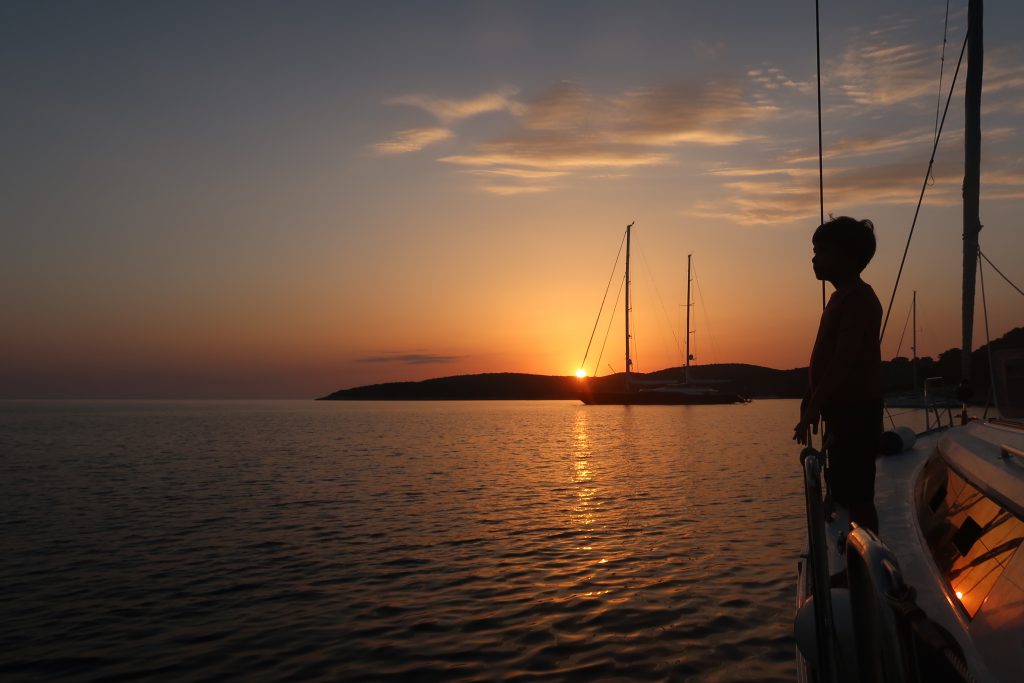 Child on sailing yacht in sunset on a sailing vacation in Croatia